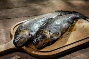 fresh rainbow trout on wooden cutting board